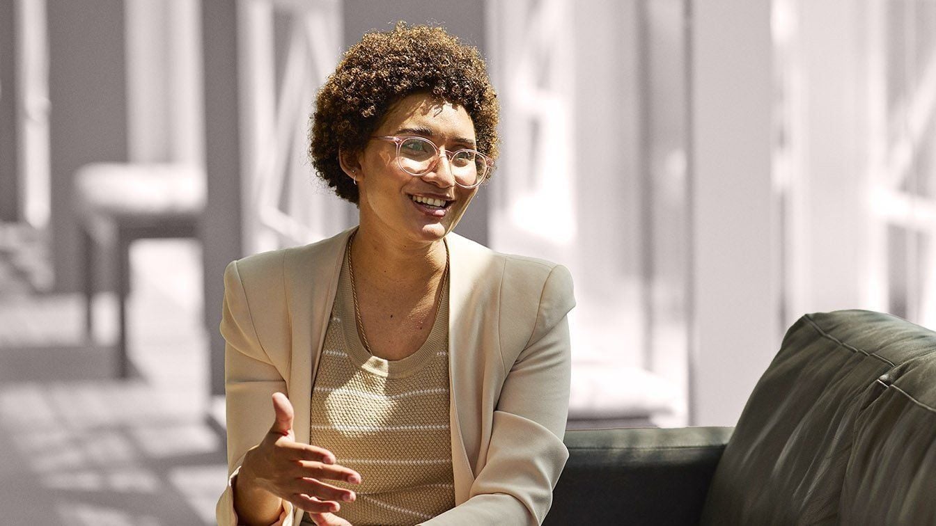 Image for RHR’s About Us and Careers section featuring a professional woman smiling during a conversation in a modern office setting, representing collaboration, inclusion, leadership, and workplace connection at RHR.