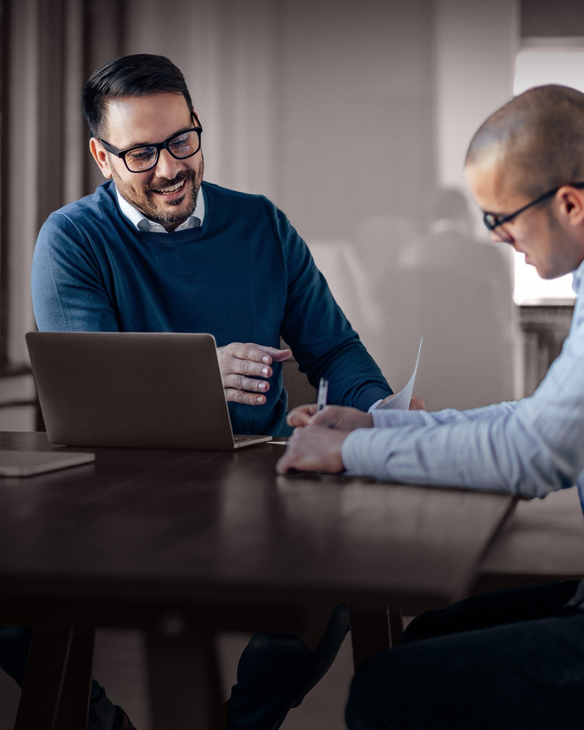 Two professionals reviewing information together, illustrating RHR’s assessment and benchmarking approach by combining data, expertise, and collaborative insight to evaluate leadership capabilities and support informed talent decisions.