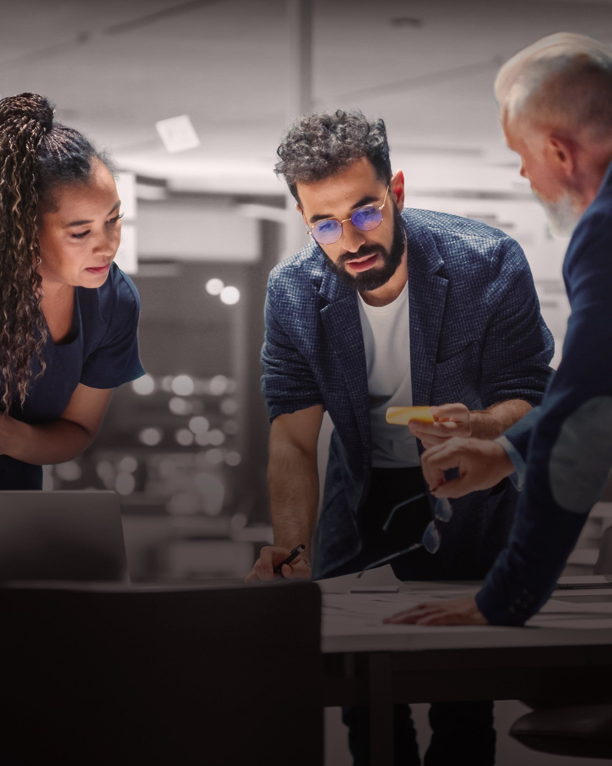 Three professionals collaborating around a table, illustrating RHR’s team effectiveness solutions by fostering alignment, open dialogue, and shared problem-solving to help teams perform at their highest level.