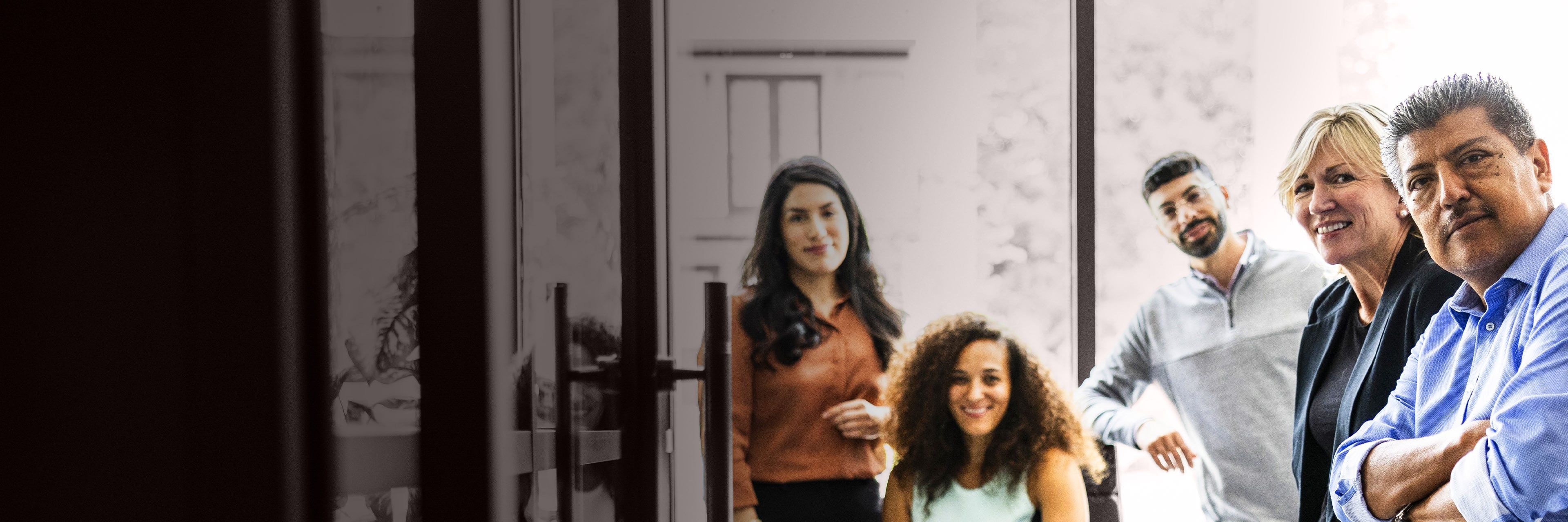 Diverse group of business professionals in a collaborative office setting, representing leadership, teamwork, and organizational alignment.