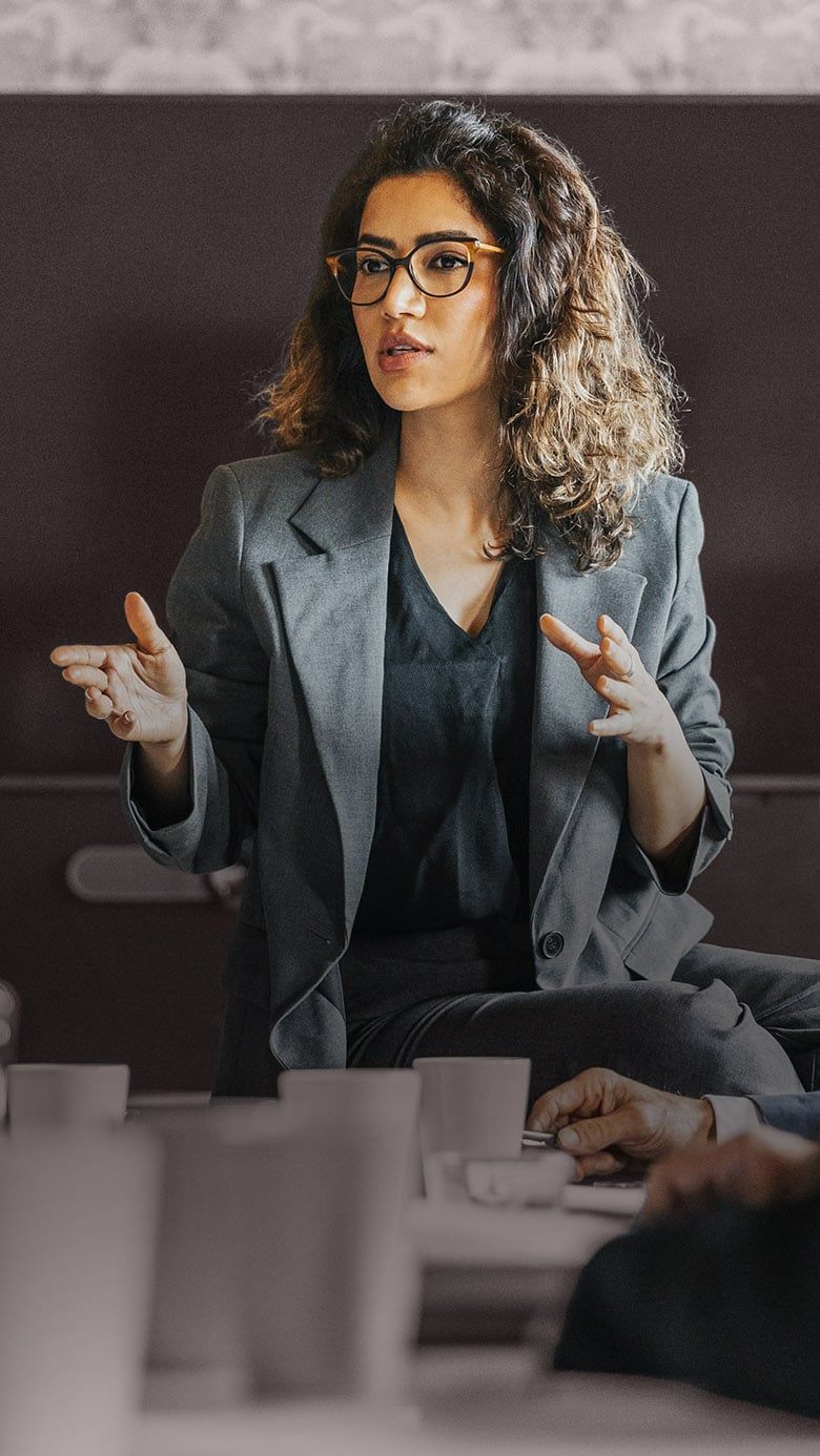 Executive speaking during a leadership meeting, representing strategic communication, collaboration, and executive decision-making.