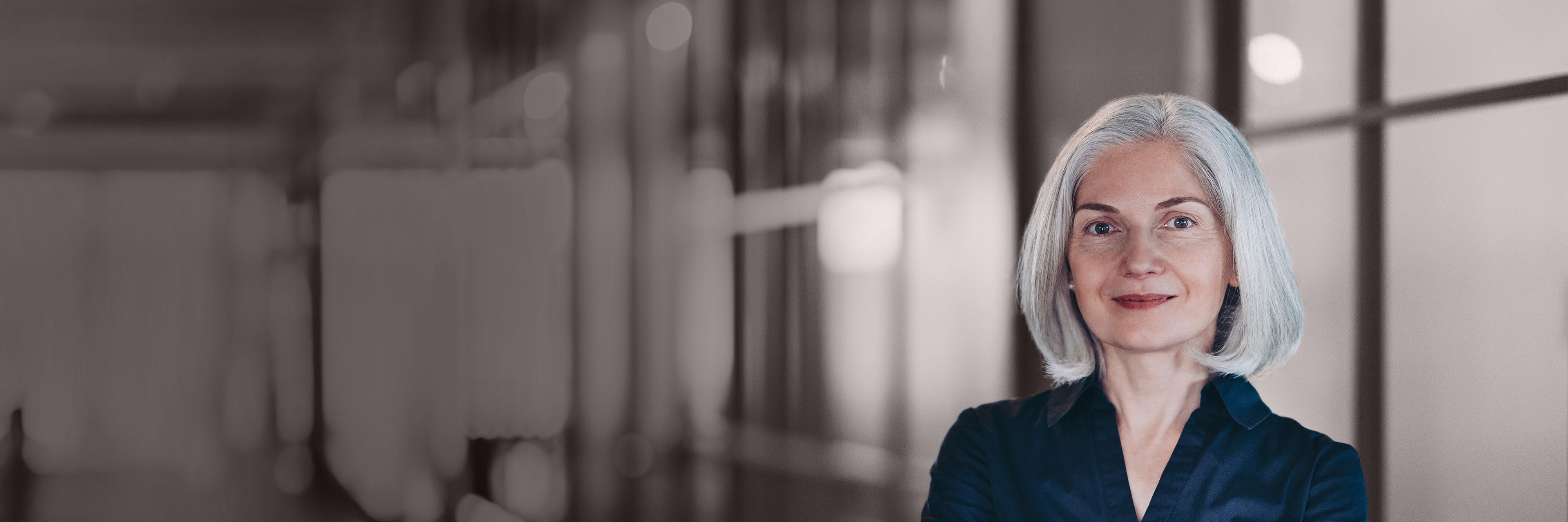 Senior executive with arms crossed in an office setting, representing confidence, leadership, and executive presence.