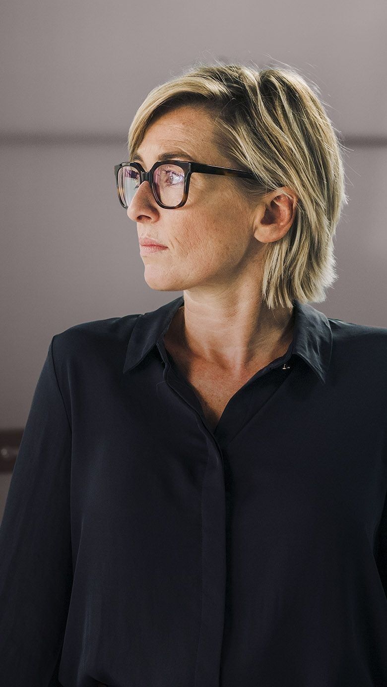 Executive wearing glasses in an office setting, representing thoughtful leadership, focus, and strategic decision-making.