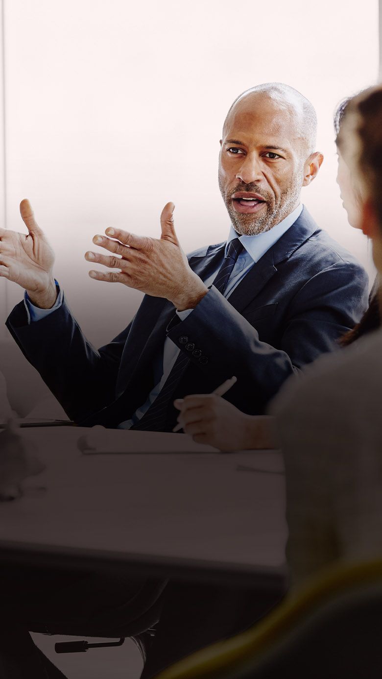 Executive leading a discussion in a boardroom meeting, representing leadership communication, strategic alignment, and executive collaboration.