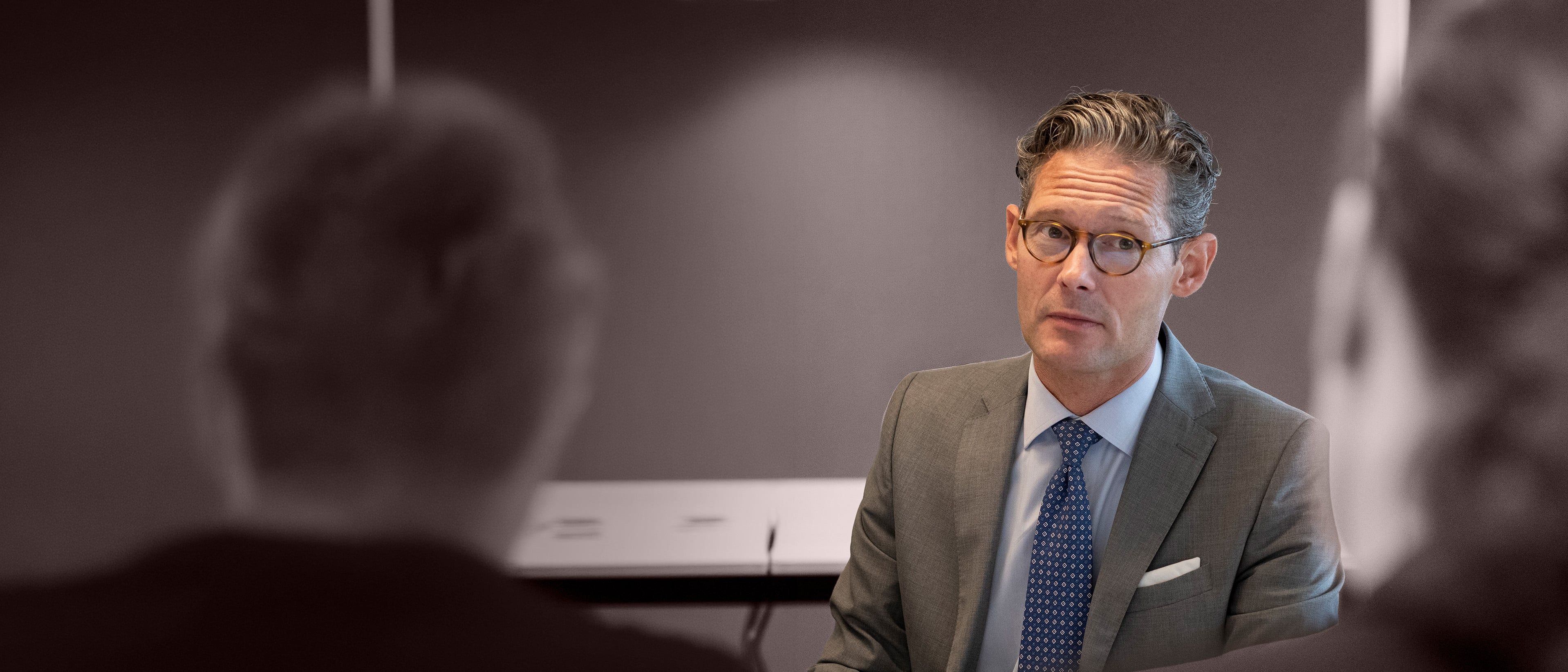Executive listening in a meeting, representing senior leadership alignment during merger and acquisition integration.