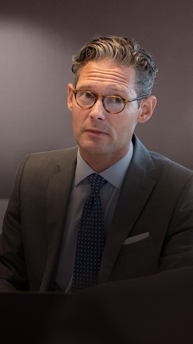 Close-up of an executive in a meeting, representing leadership focus during M&A transition and integration.