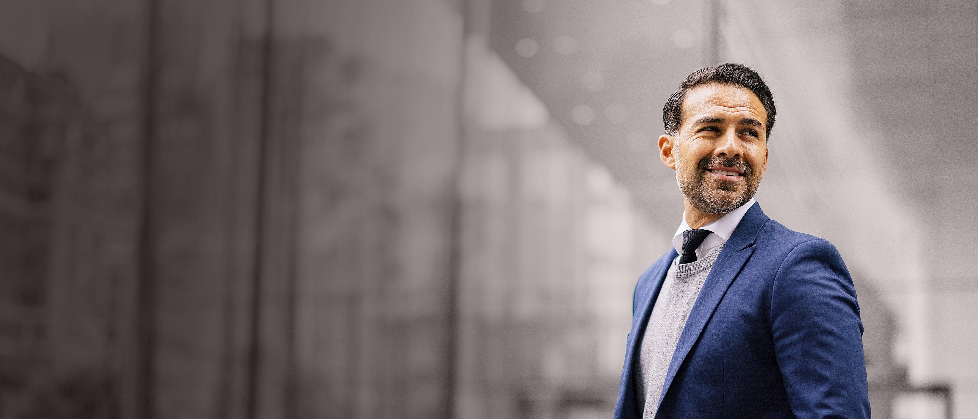 Wide banner image of a professional businessman in a corporate setting, representing confidence, future leadership potential, and RHR’s Emerging Talent Solutions.