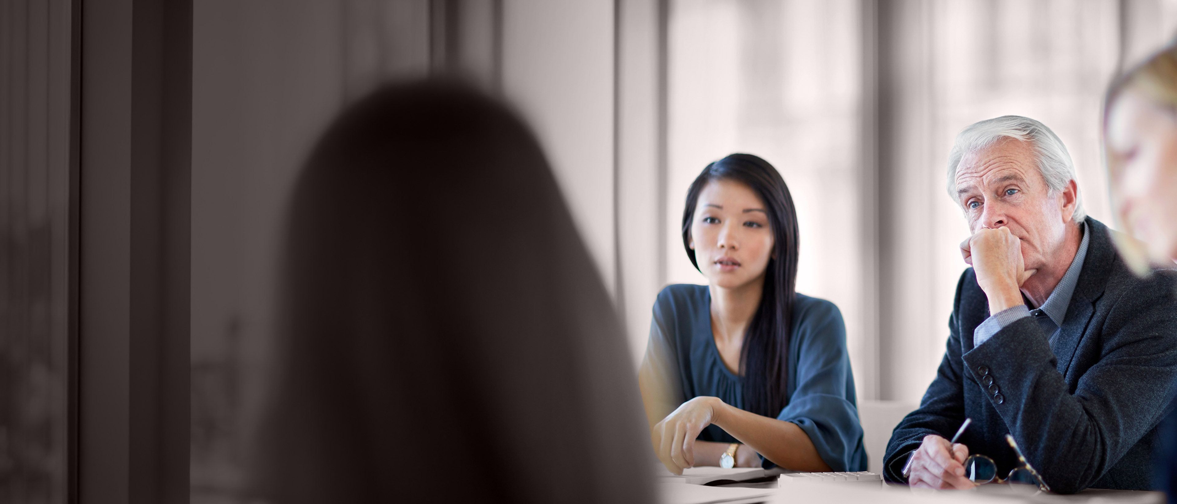 Wide banner image of board members in discussion during a meeting, representing governance, board effectiveness, and RHR’s Board Evaluation and Development Solutions.