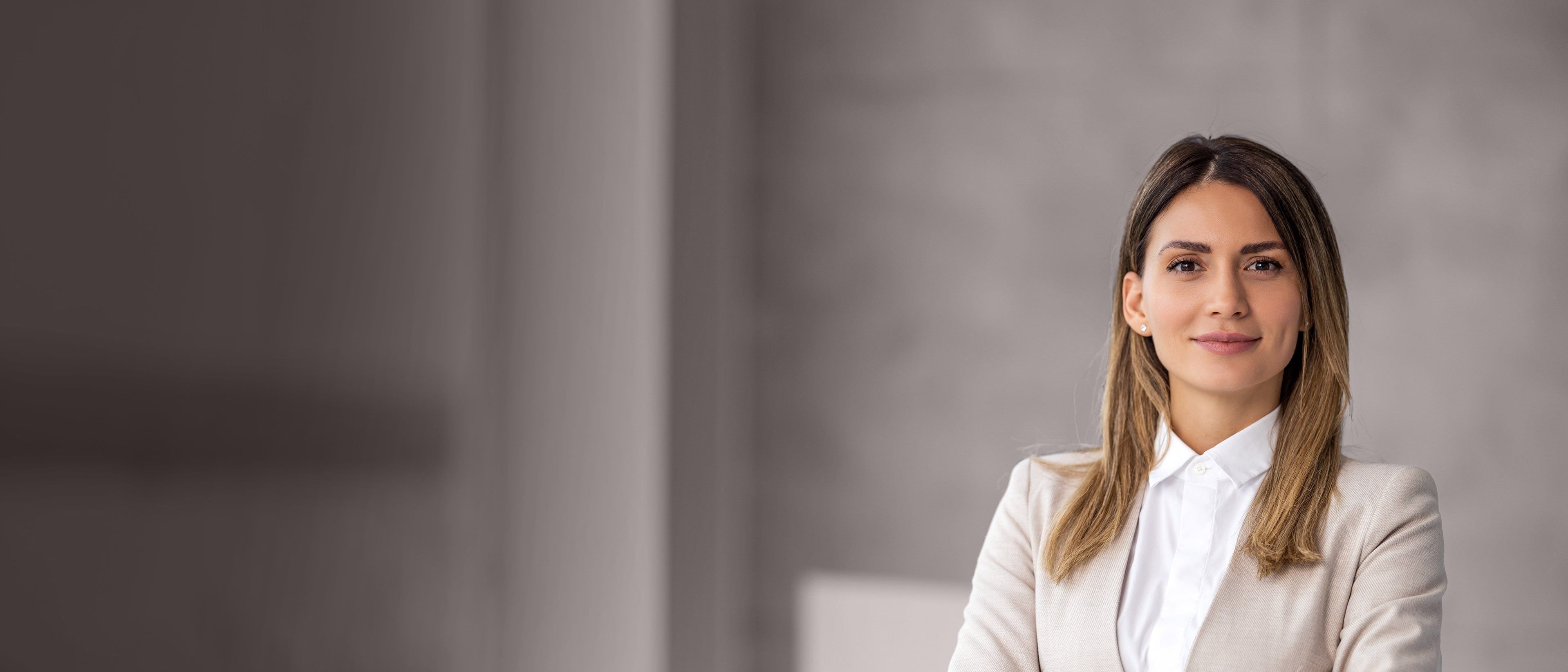 Wide banner image of a professional businesswoman in a corporate setting, representing executive coaching, leadership development, and RHR’s C-Suite Advisory Coaching Solutions.