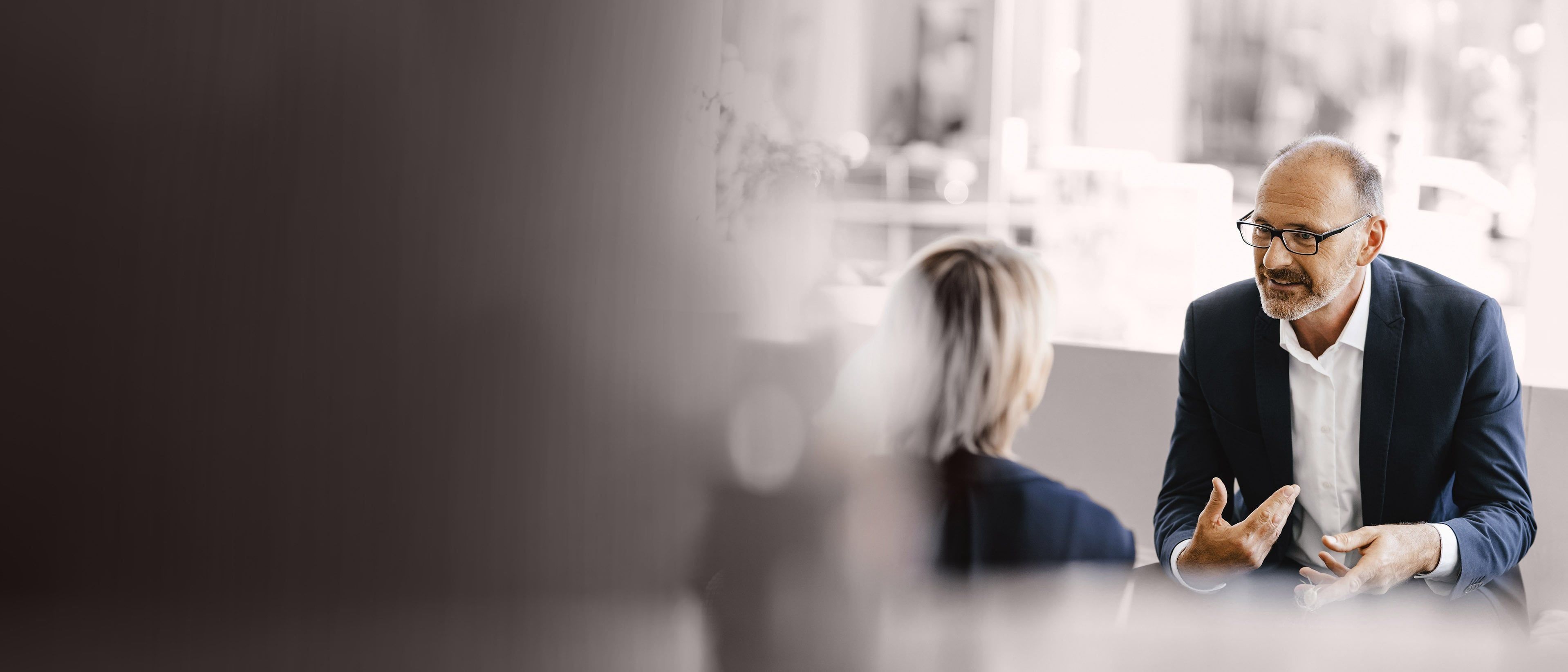 Wide banner image of business professionals in a coaching discussion, representing leadership development, executive growth, and RHR’s Executive Coaching services.