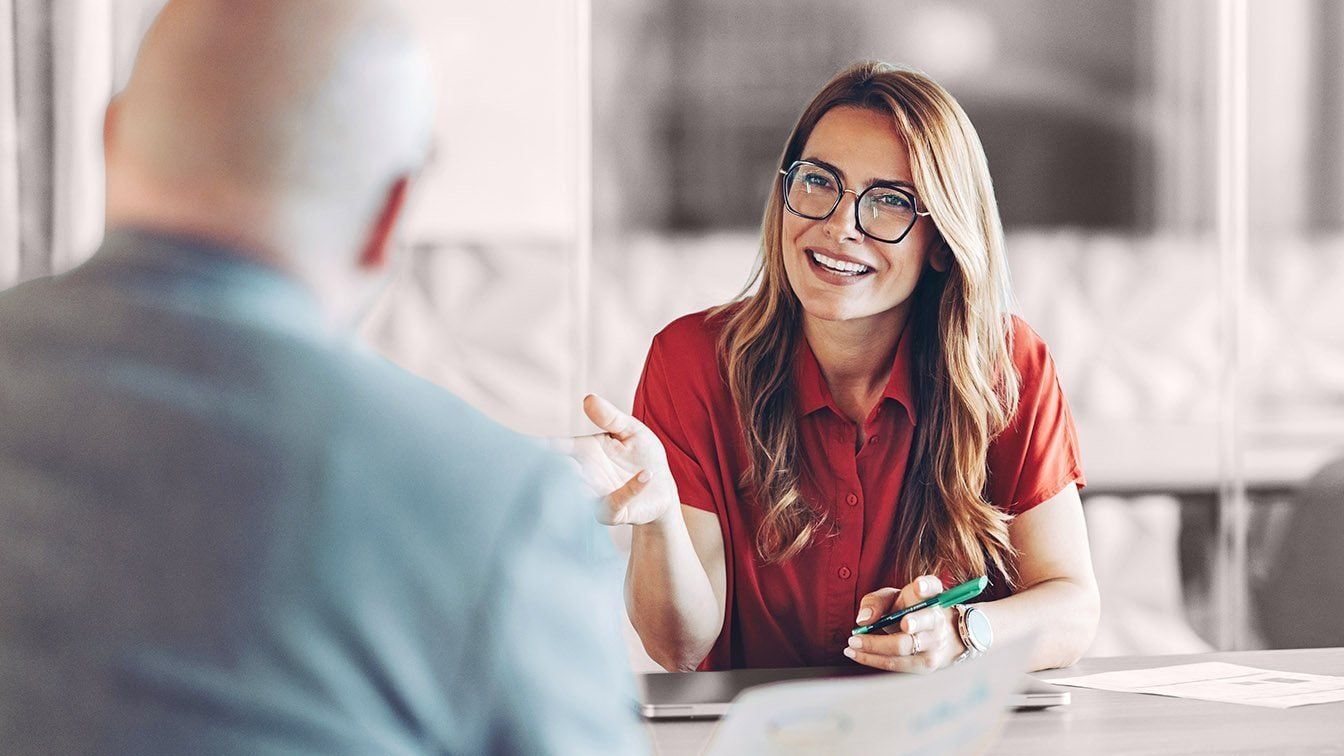 Image of a business professional engaged in a coaching conversation during a meeting, representing leadership development, executive growth, and RHR’s Executive Coaching services.