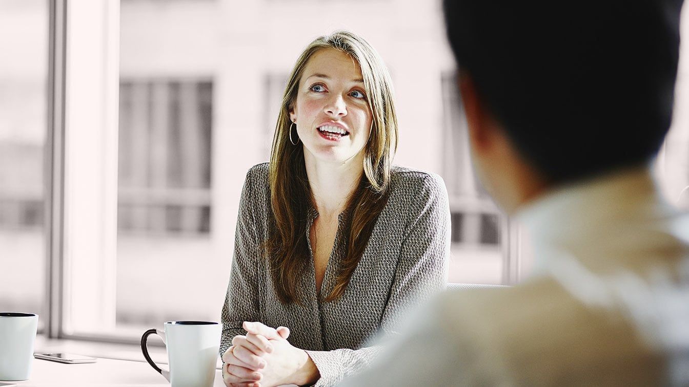 Image of a business professional speaking during a meeting, representing leadership advancement, talent development, and RHR’s Internal Promotion Solutions.