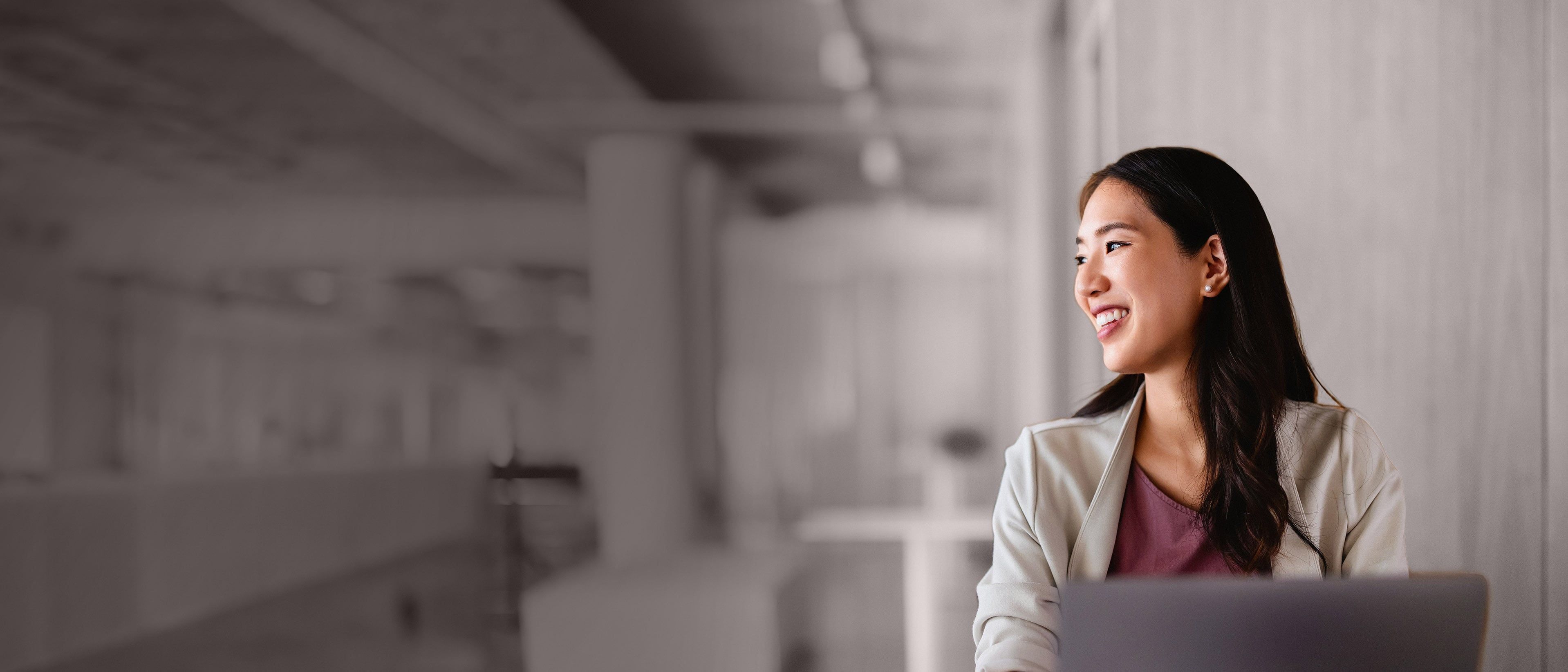 Wide banner image of a professional businesswoman in a corporate setting, representing executive onboarding, leadership integration, and RHR’s Onboarding and Transition Services.
