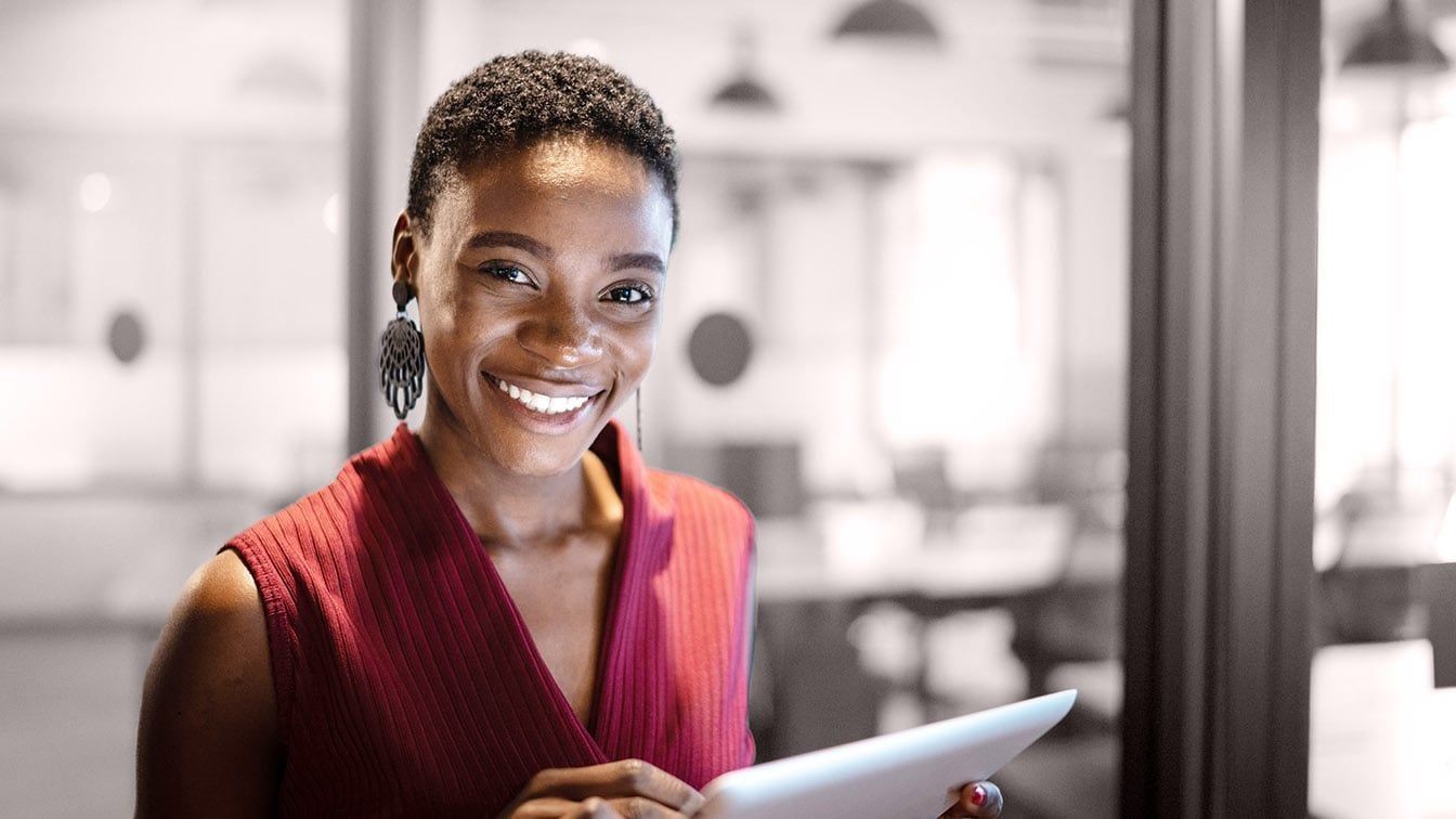 Image of a professional businesswoman holding a tablet in a corporate office, representing executive onboarding, leadership transition, and RHR’s Onboarding and Transition Services.