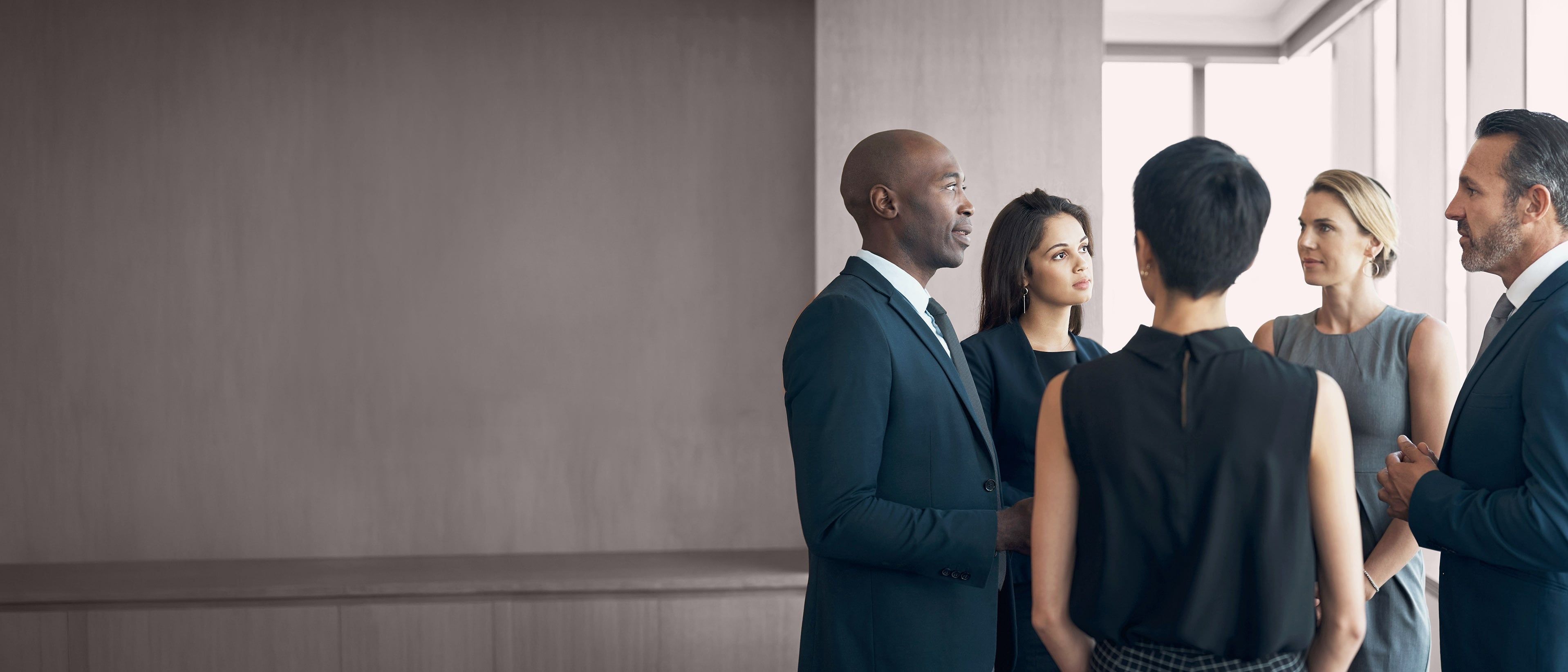 Wide banner image of diverse business professionals in discussion, representing collaboration, inclusive leadership, and RHR’s Culture of High Performance and Belonging solutions.