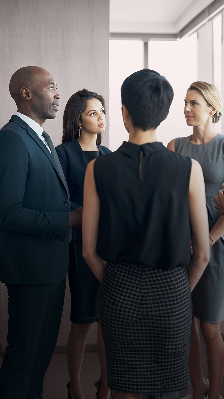 Portrait image of diverse business professionals in discussion, representing collaboration, inclusive leadership, and RHR’s Culture of High Performance and Belonging solutions.