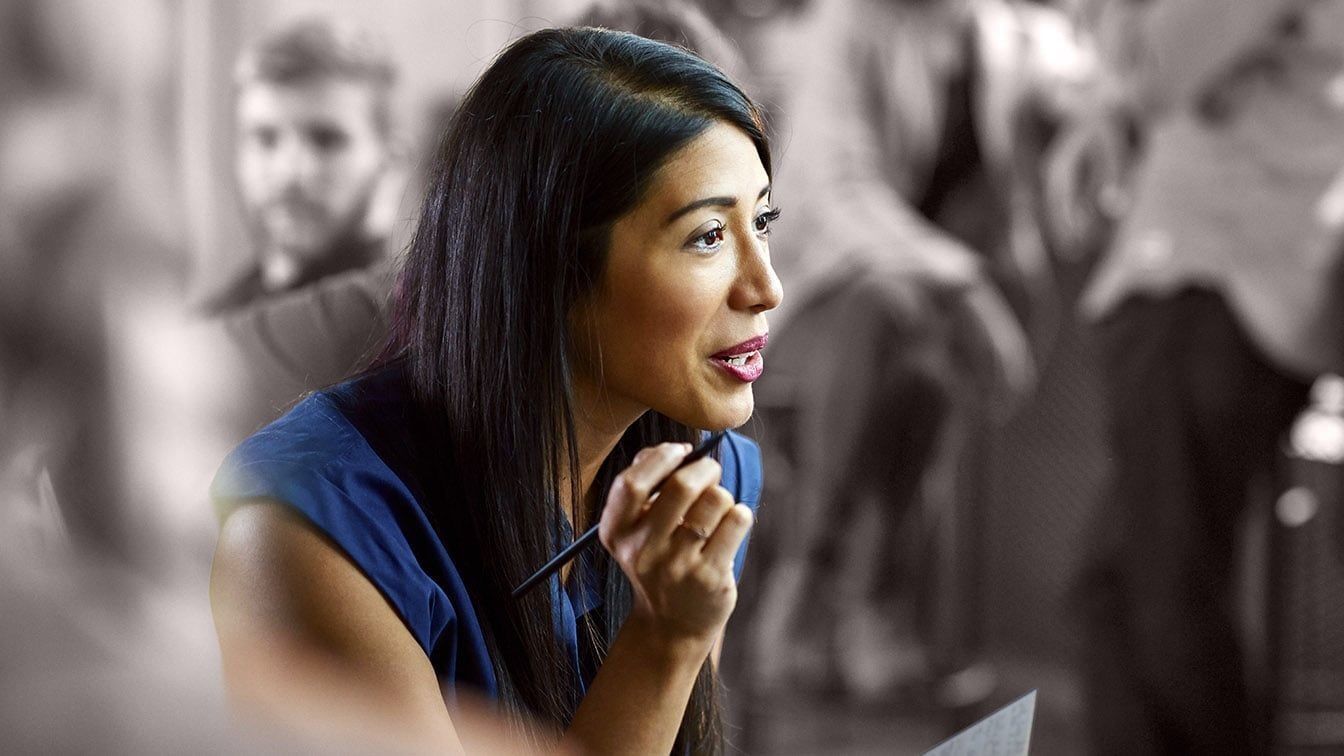 Image of a business professional speaking during a collaborative meeting, representing inclusive leadership, employee engagement, and RHR’s Culture of High Performance and Belonging solutions.