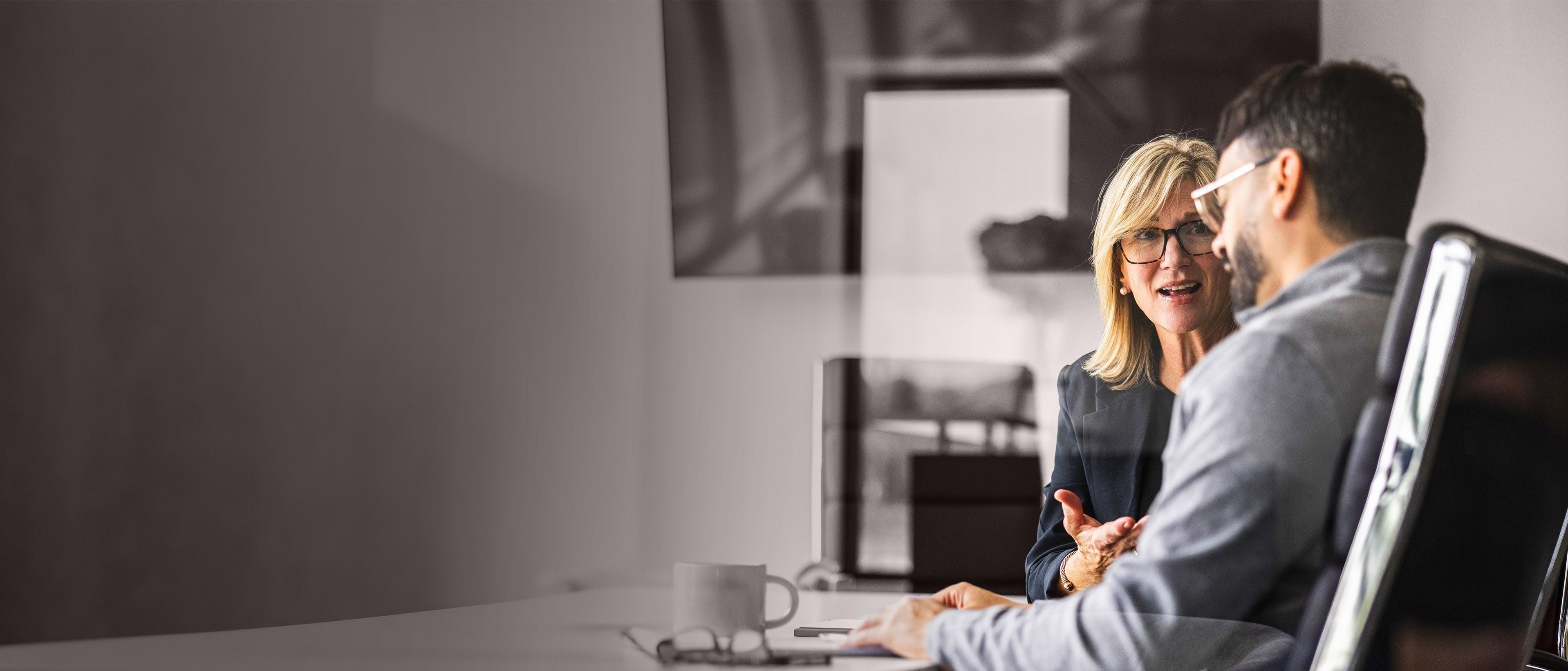 Wide banner image of business professionals in a leadership discussion, representing succession readiness, leadership development, and talent pipeline growth through RHR’s Succession Planning and Developing Talent Solutions.