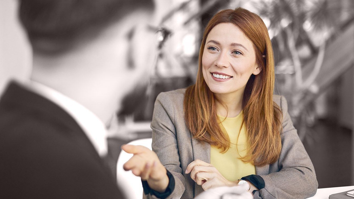 Image of business professionals in conversation during a meeting, representing leadership development, succession readiness, and talent growth through RHR’s Succession Planning and Developing Talent Solutions.