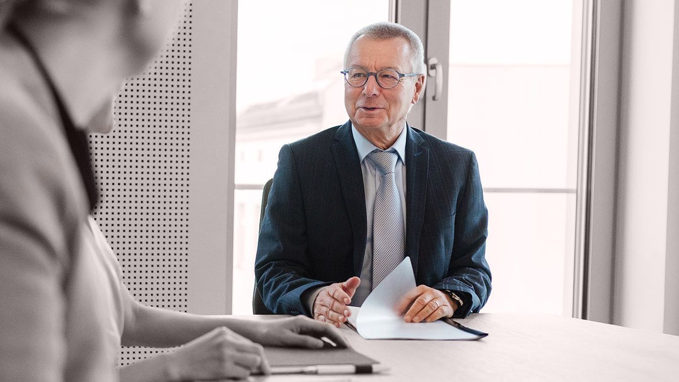 Image of a senior business leader in a professional meeting, representing leadership role definition, succession readiness, and talent alignment through RHR’s Succession Planning and Role Profiling Solutions.