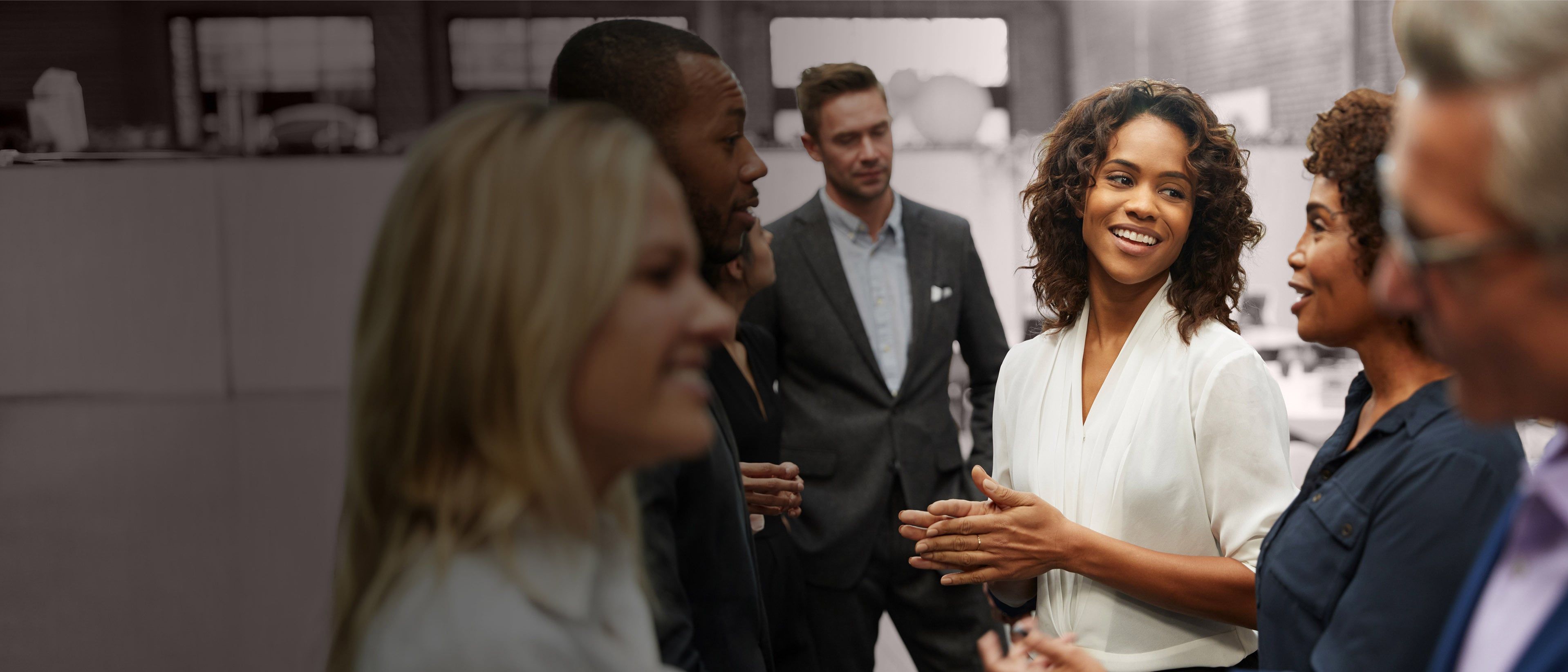 Wide banner image of executive leaders engaged in conversation, representing executive team alignment, leadership collaboration, and RHR’s CEO and Direct Report Teams Solutions.