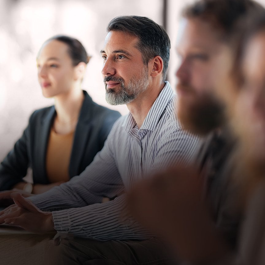 Diverse corporate leaders collaborating in an executive session focused on enterprise leadership development.