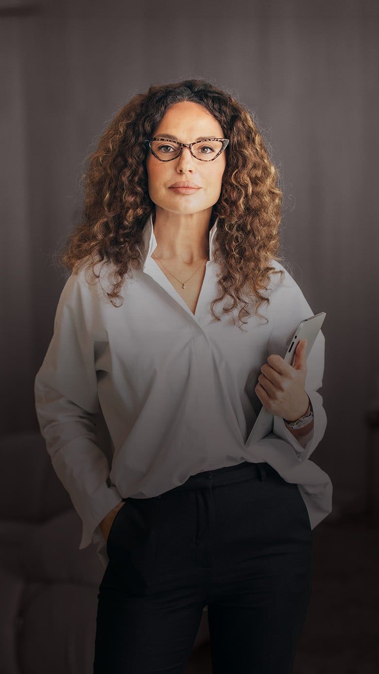 Executive leader with tablet standing in a modern office, representing RHR private equity advisory services.