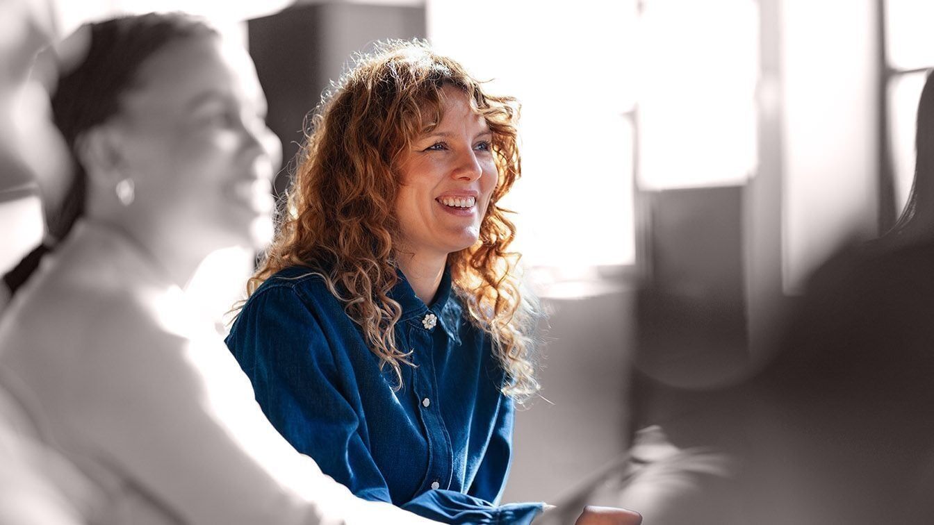 Professional engaged in conversation during a collaborative discussion, representing the leaders, teams, and organizations RHR works with to build leadership capability, strengthen performance, and create lasting impact.